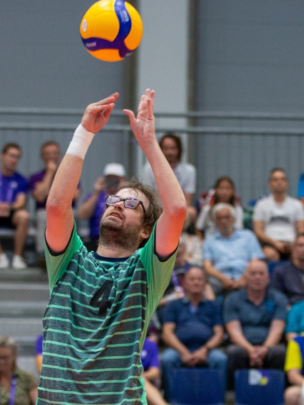 Mann mit Brille spielt Volleyball