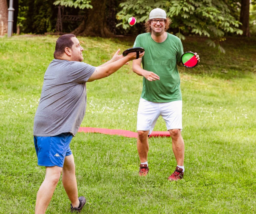 Zwei Männer spielen ein Ballspiel im Park.